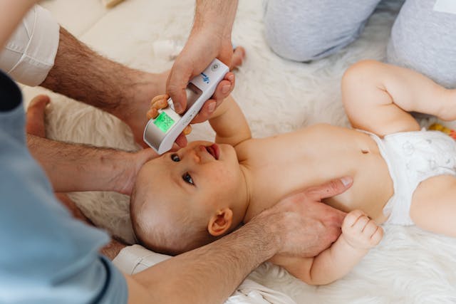 bebe-con-fiebre bebe con fiebre tomándole la temperatura
